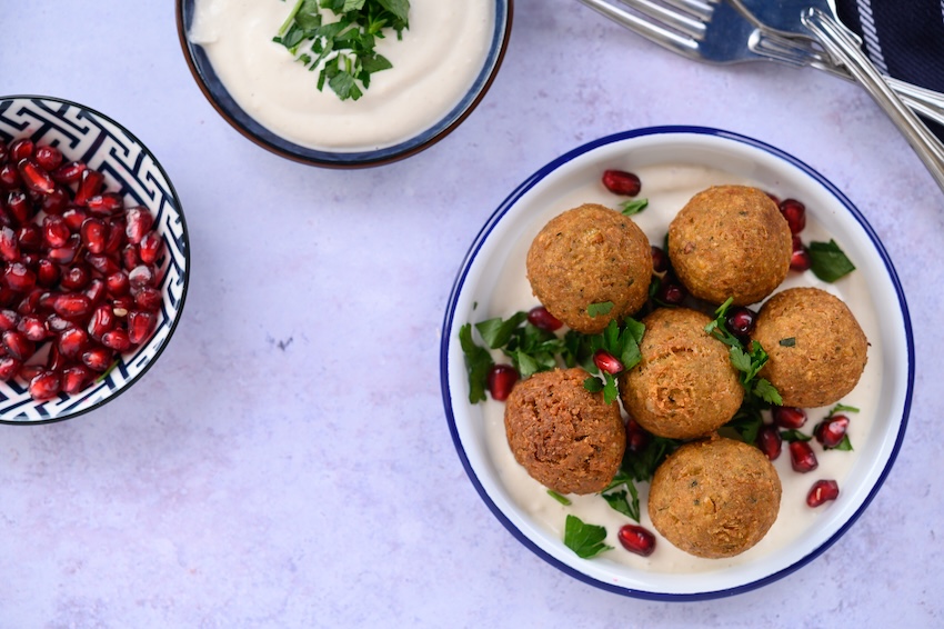 Spicy lentil balls with yogurt dip and pomegranate